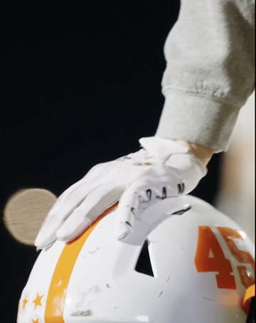 Hand resting on football helmet