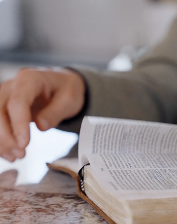 Bible open with person flipping pages
