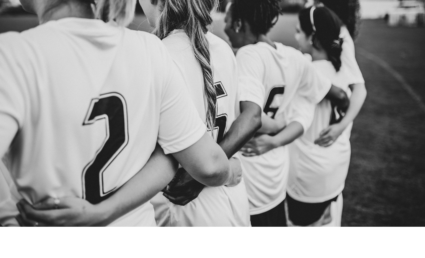 Four female athletes linking arms.